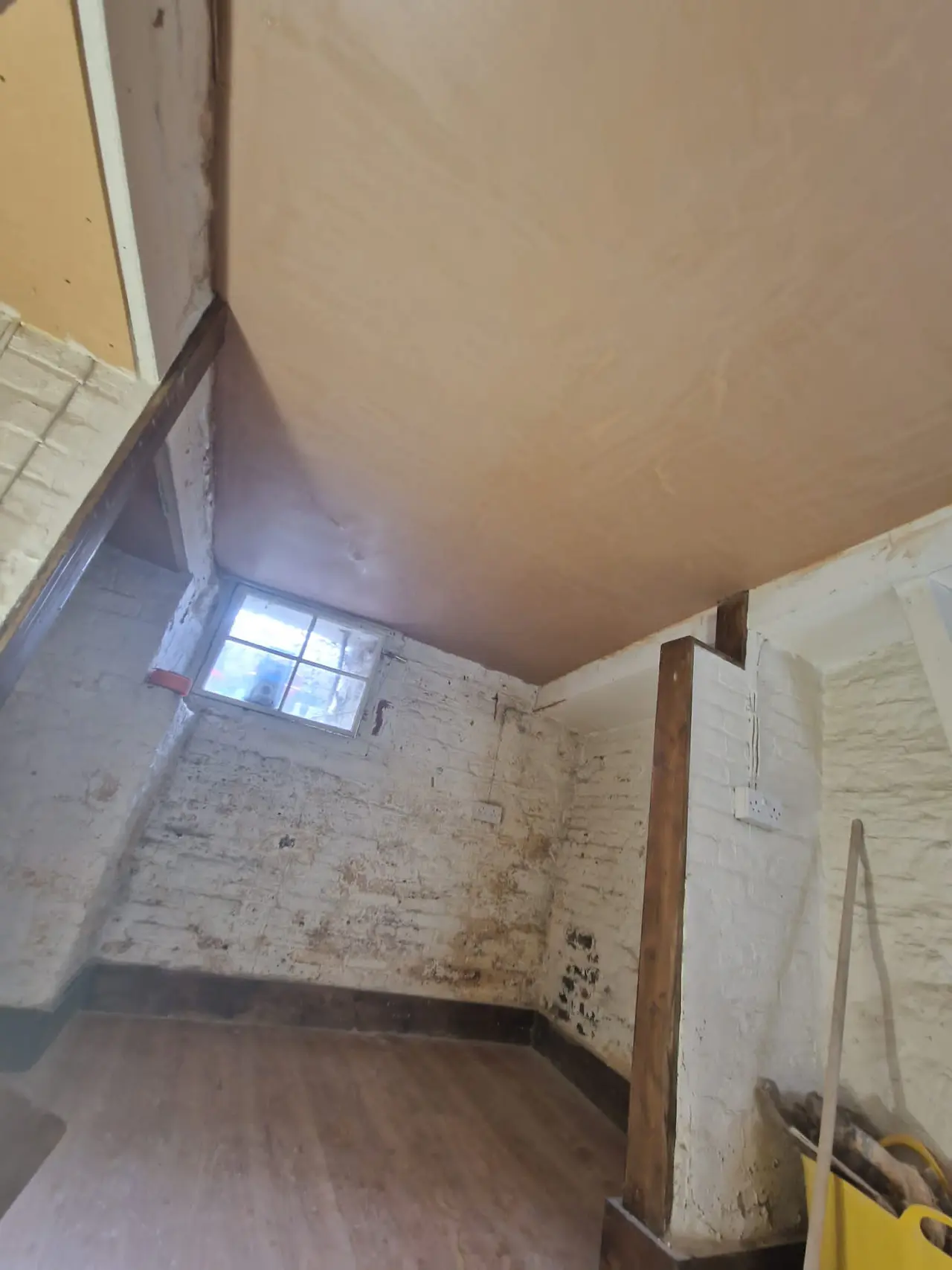 White-painted cellar room with a newly plastered ceiling during renovation