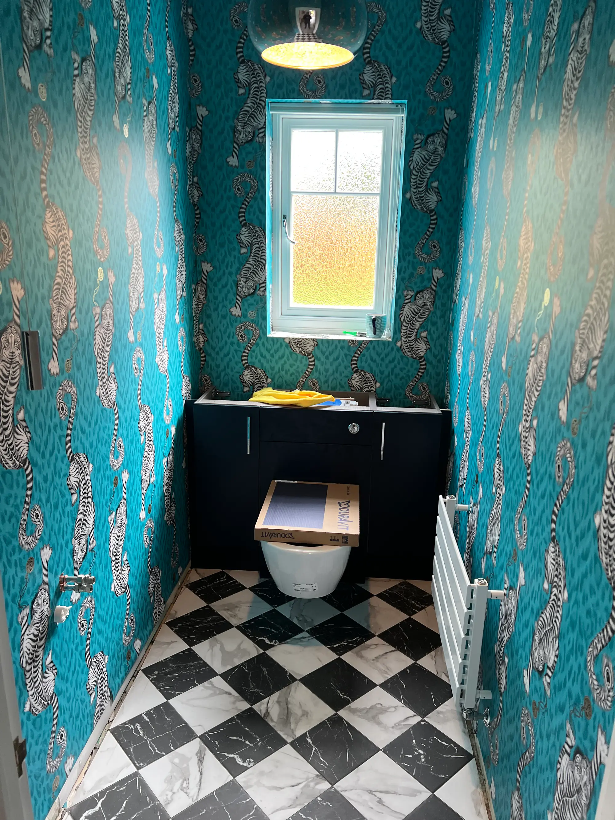 Teal patterned cloakroom with a black-and-white chequered floor