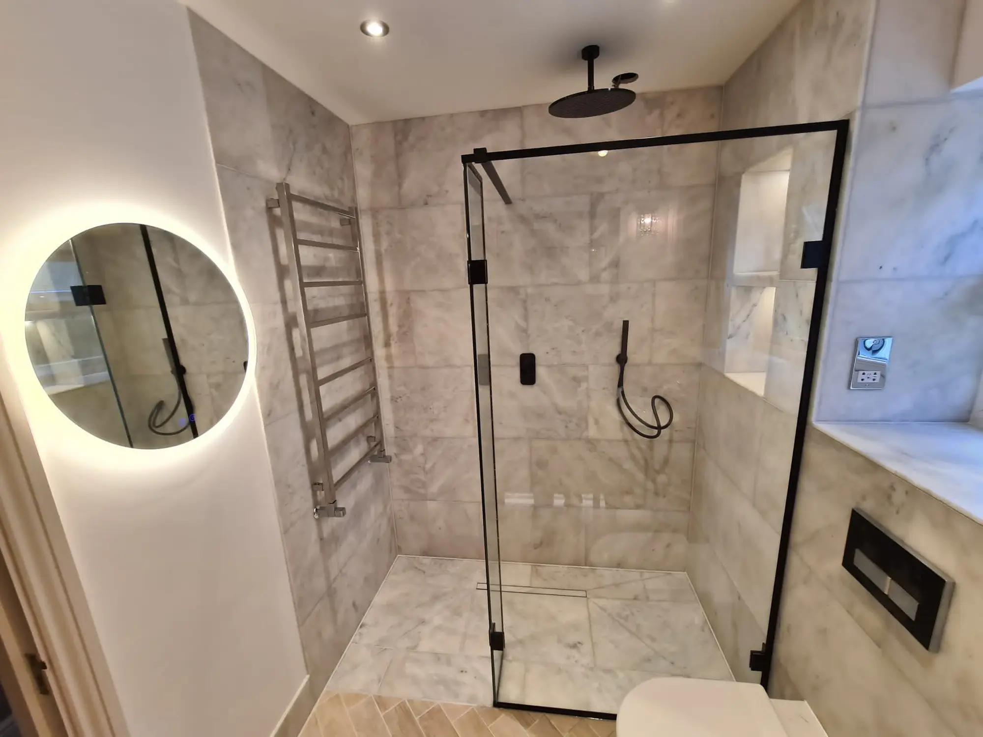 Finished marble-effect shower room with a black-framed enclosure