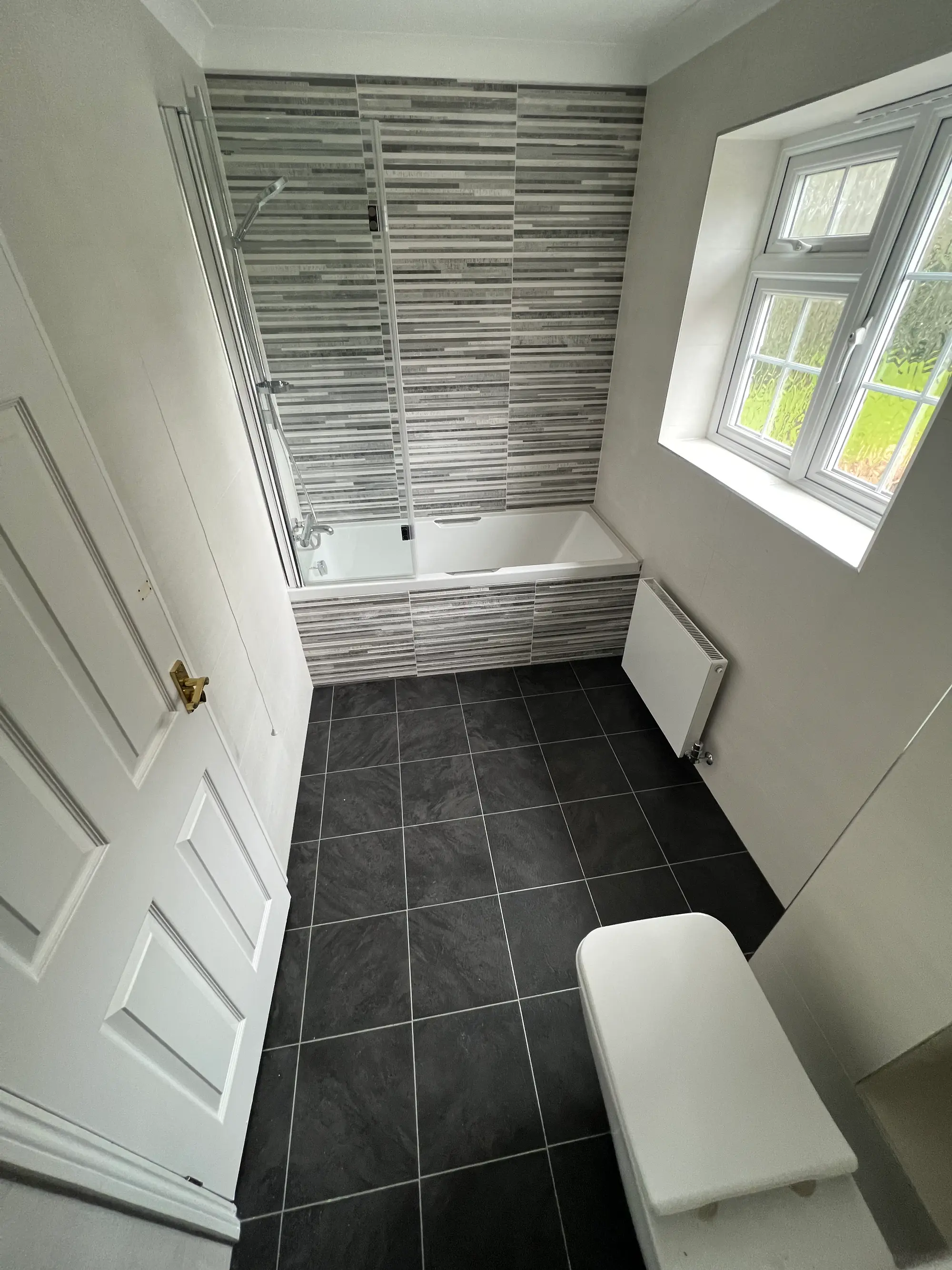 Black-and-white shower room with a wall-hung toilet and patterned floor