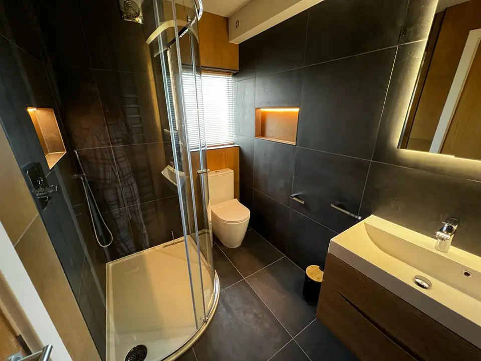 Finished black and bronze shower room with two illuminated niches