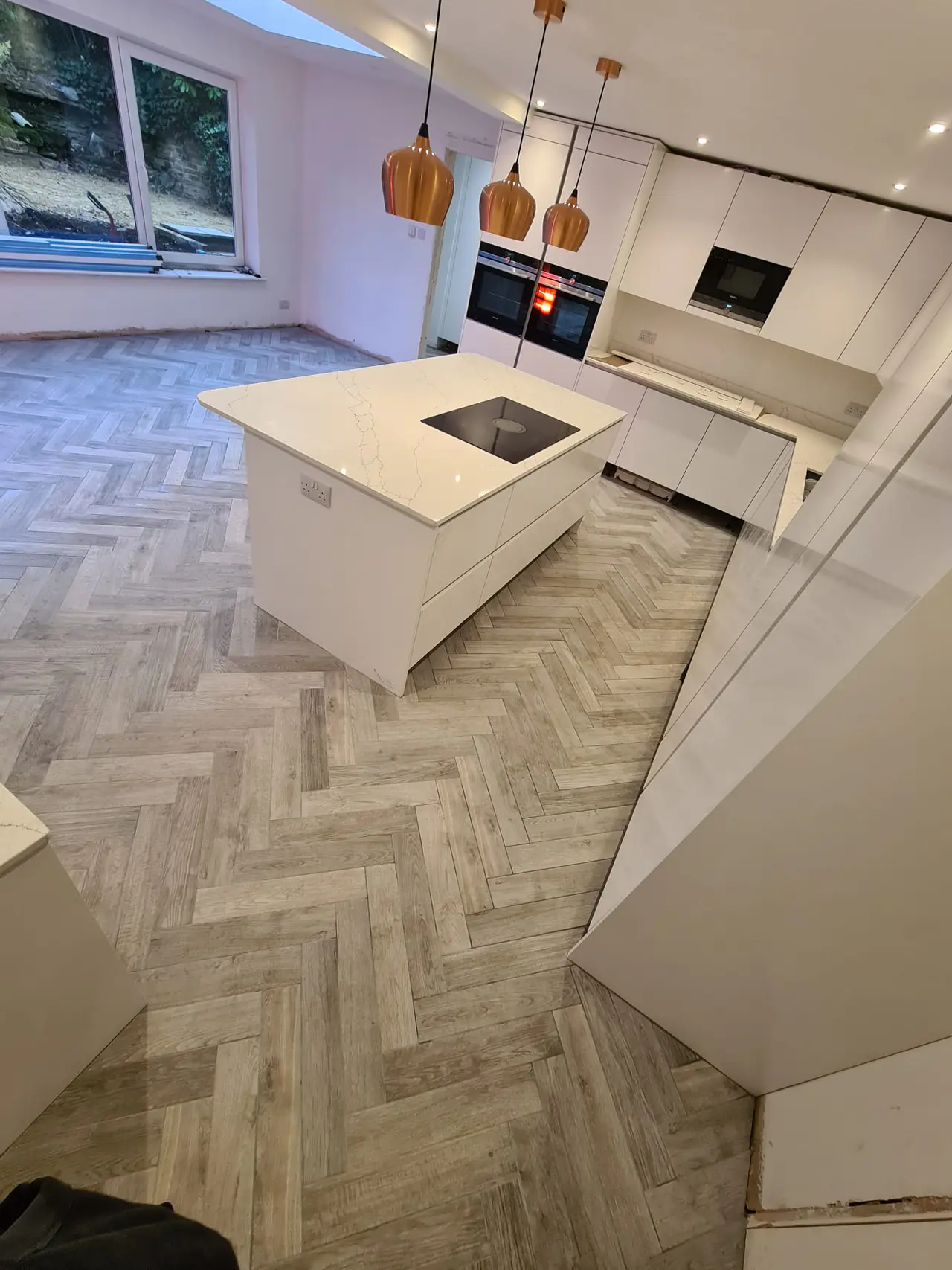 White handleless kitchen units arranged around a central island