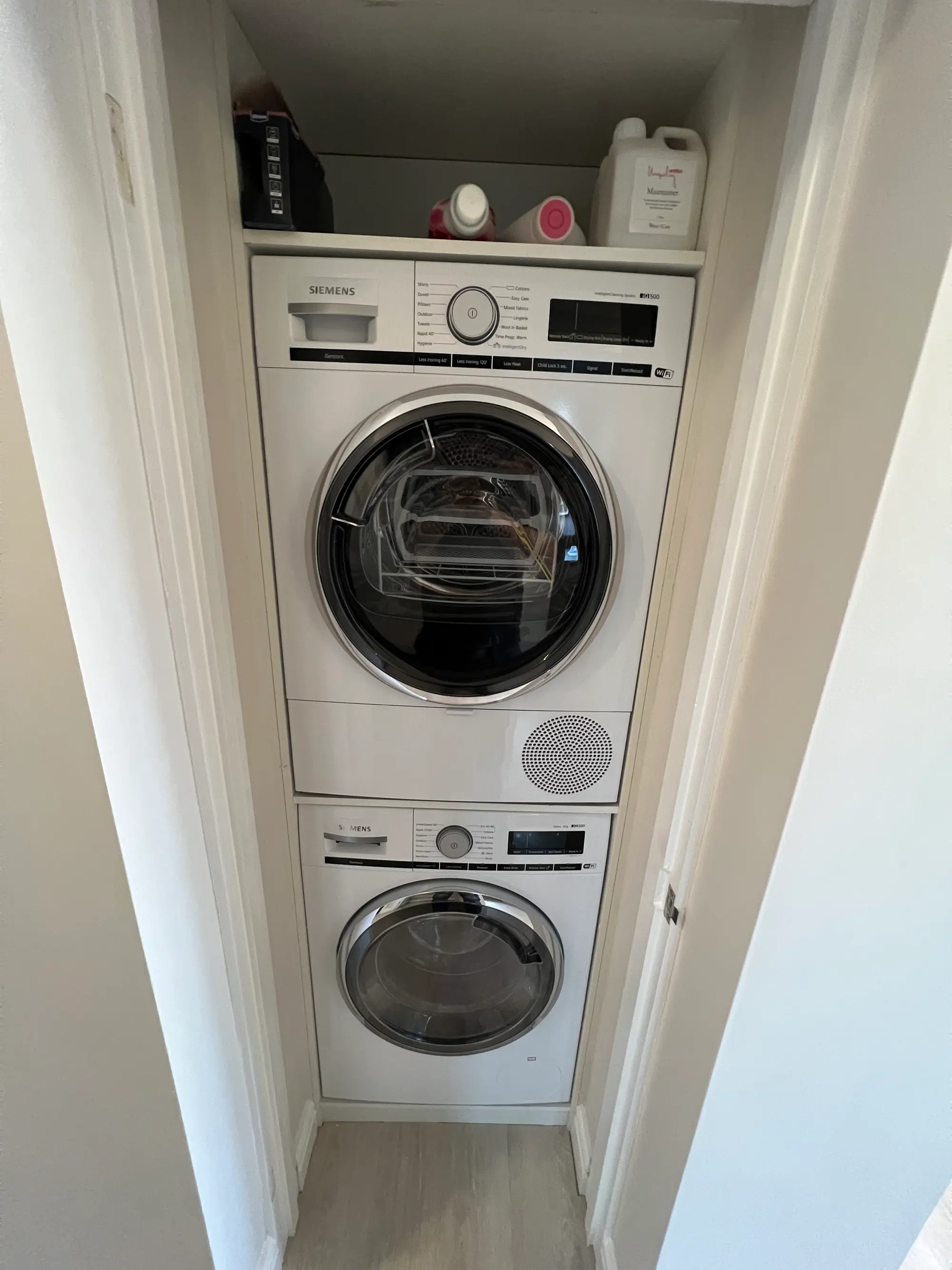 Stacked washing machine and tumble dryer fitted into a narrow utility cupboard